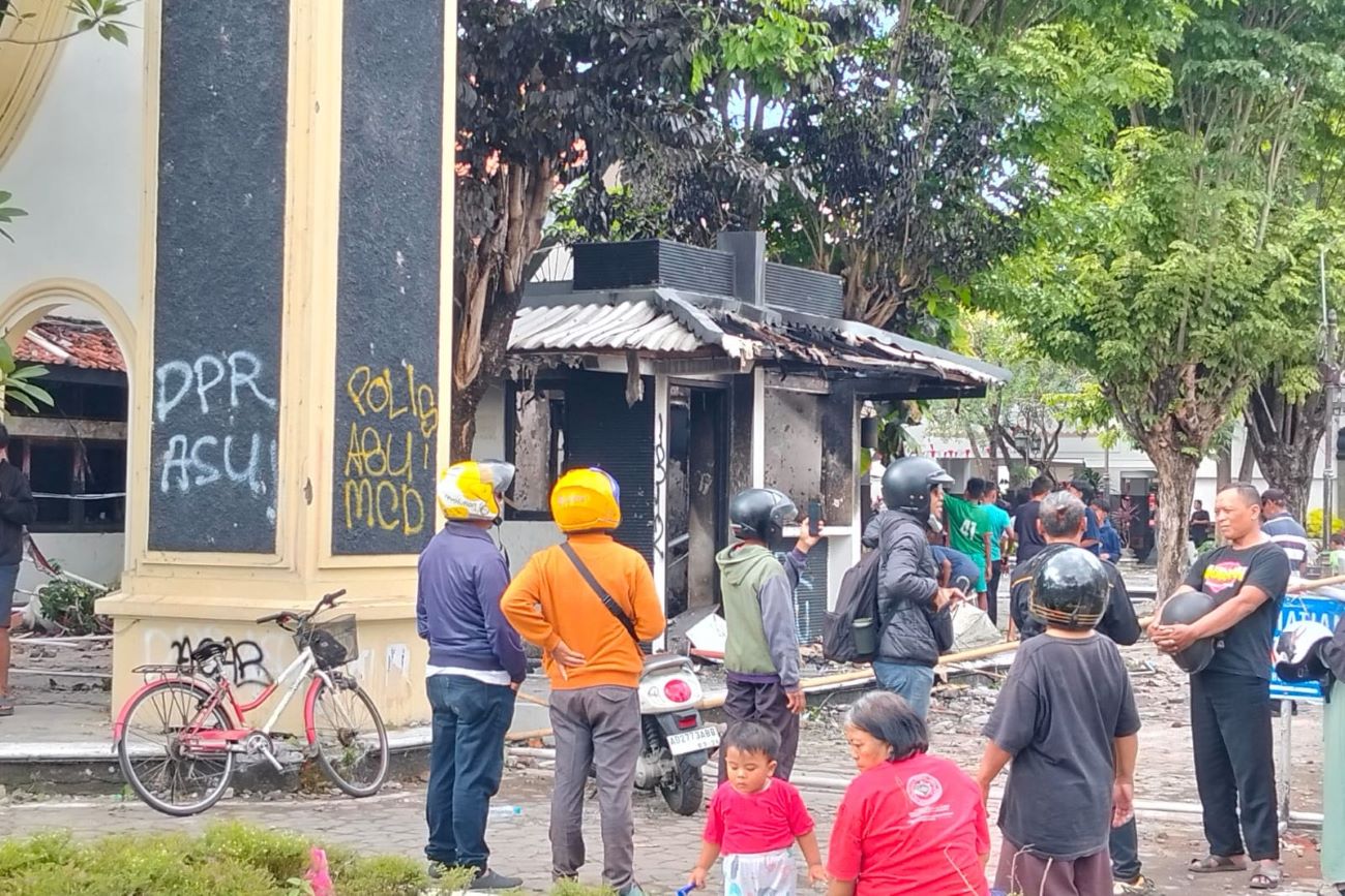 Warga, Sabtu (30/8/2025) pagi, berdatangan ke kompleks DPRD Solo yang hangus dibakar massa pada Sabtu dini hari. (Solopos/Astrid Prihatini W.D.)