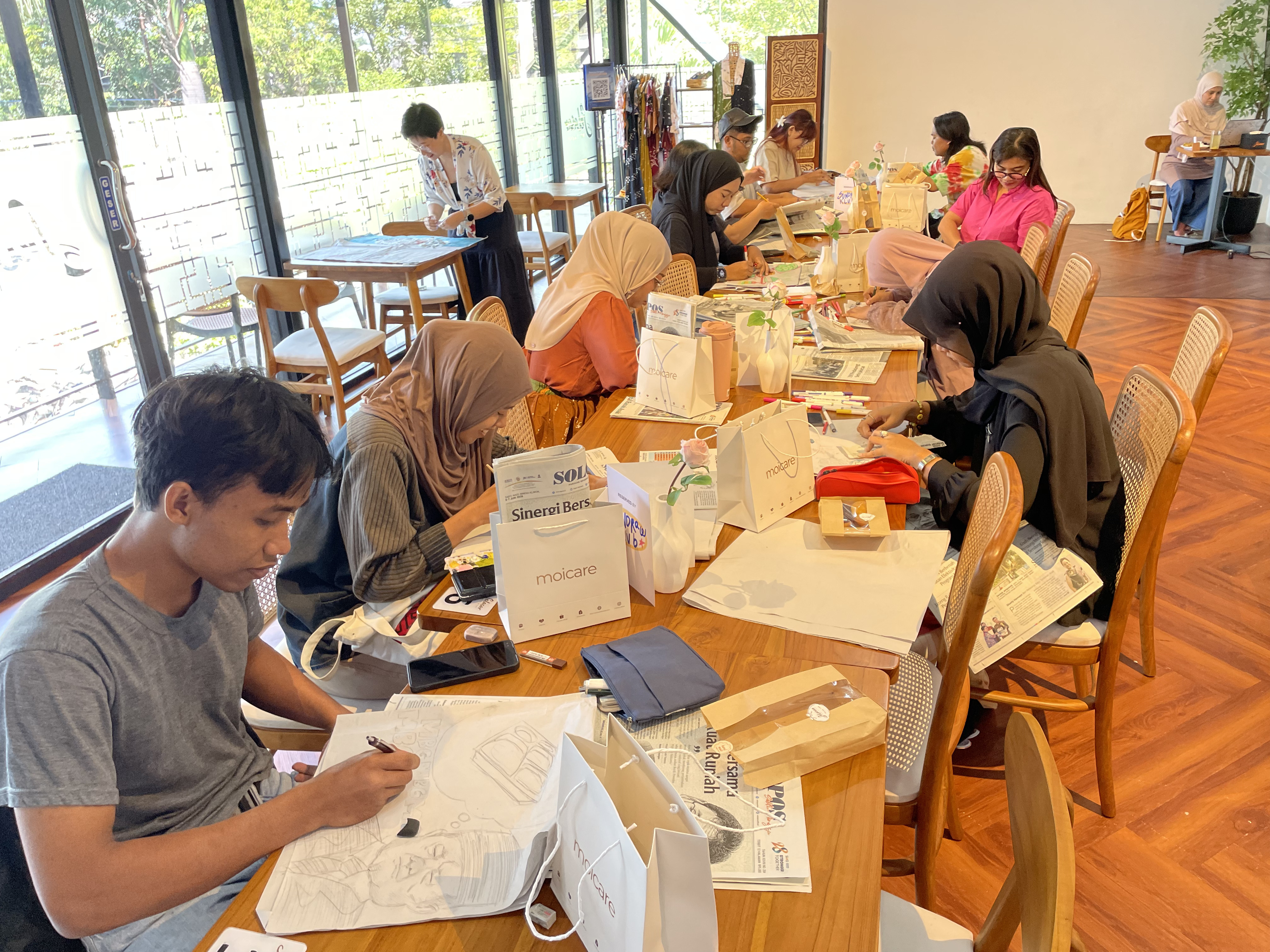 Sundraw dan Daerah mengajak peserta merespons berita melalui gambar di atas kertas koran dalam workshop Menggambar Kabar. (Daerah/Dea)