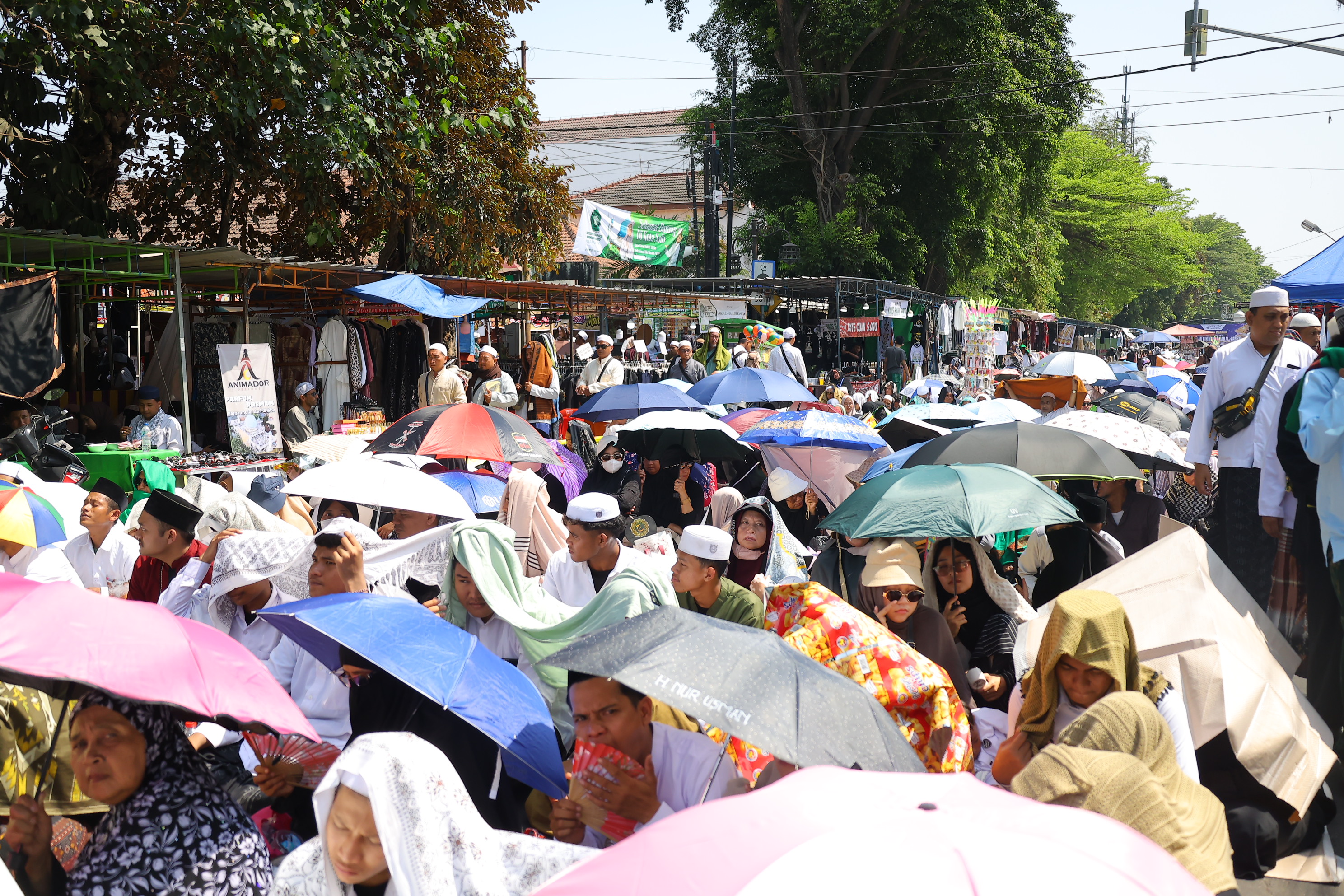 Peziarah duduk saat menghadiri haul atau peringatan wafatnya Habib Ali bin Muhammad Al Habsyi di Pasar Kliwon, Solo, Sabtu (3/10/2026). Meskipun cuaca panas perayaan Haul ulama Habib Ali tersebut dihadiri ribuan orang yang datang dari berbagai kota di Indonesia.(Daerah/J Howi Widodo).