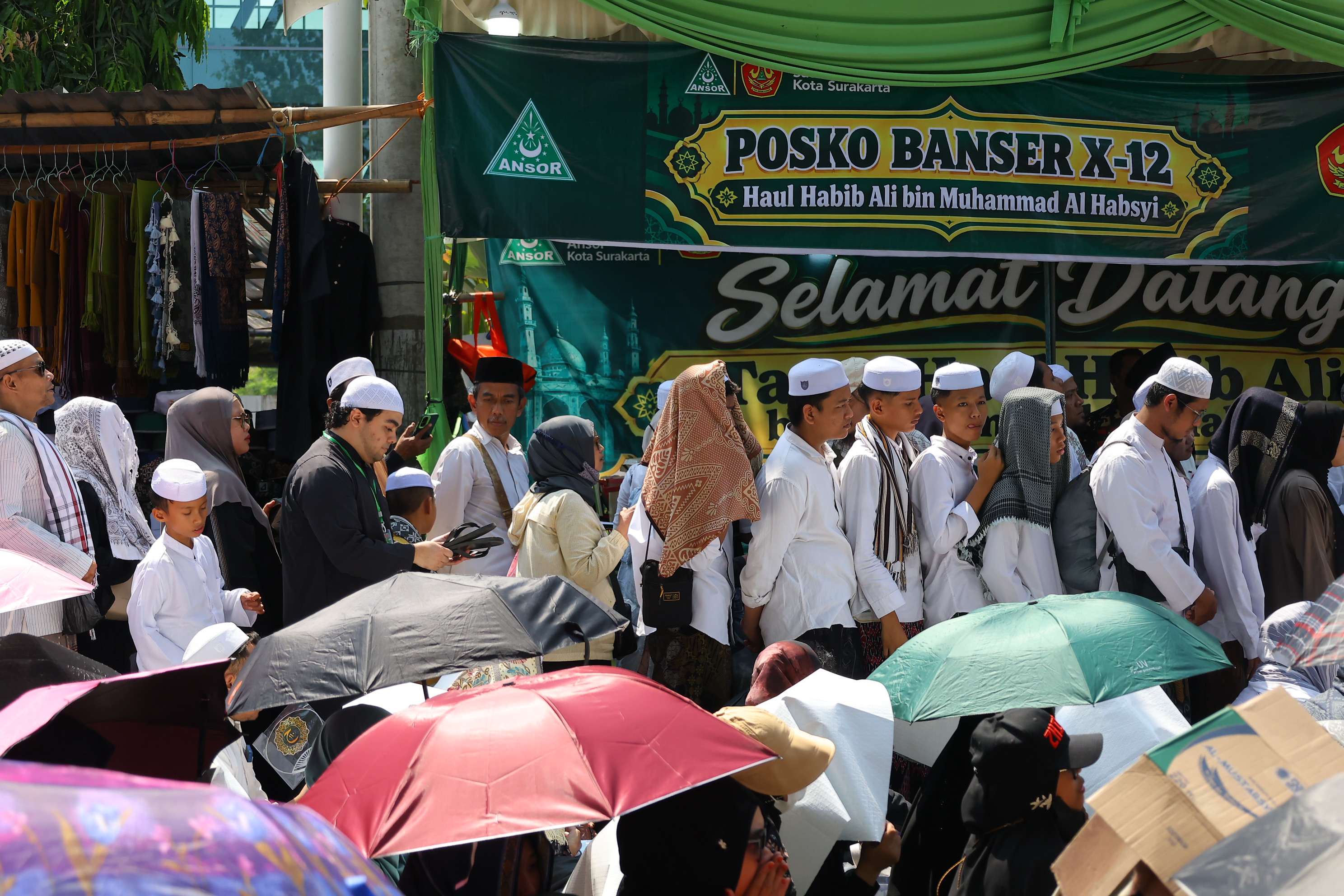 Peziarah melintas saat menghadiri haul atau peringatan wafatnya Habib Ali bin Muhammad Al Habsyi di Pasar Kliwon, Solo, Sabtu (3/10/2026). Meskipun cuaca panas perayaan Haul ulama Habib Ali tersebut dihadiri ribuan orang yang datang dari berbagai kota di Indonesia.(Daerah/J Howi Widodo).