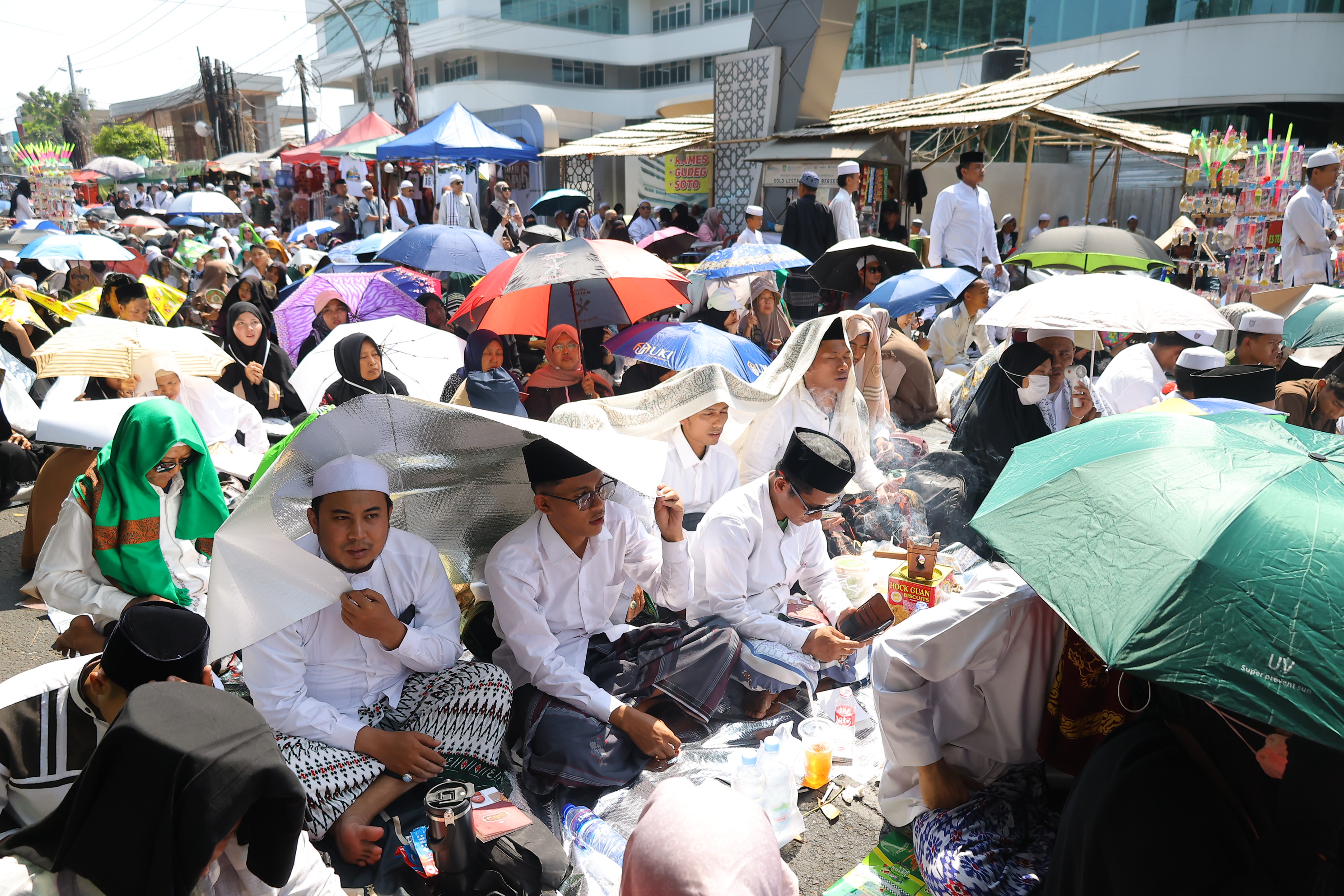 Peziarah duduk saat menghadiri haul atau peringatan wafatnya Habib Ali bin Muhammad Al Habsyi di Pasar Kliwon, Solo, Sabtu (3/10/2026). Meskipun cuaca panas perayaan Haul ulama Habib Ali tersebut dihadiri ribuan orang yang datang dari berbagai kota di Indonesia.(Daerah/J Howi Widodo).