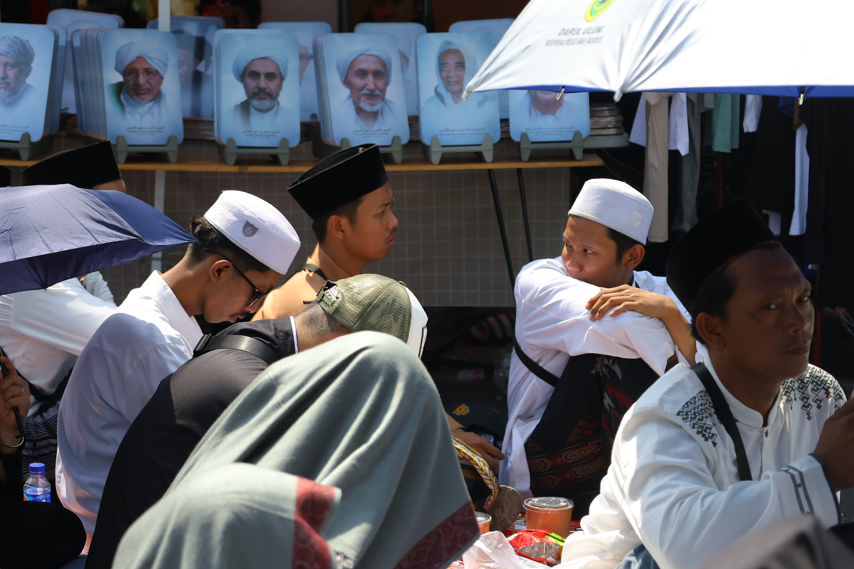 Peziarah duduk saat menghadiri haul atau peringatan wafatnya Habib Ali bin Muhammad Al Habsyi di Pasar Kliwon, Solo, Sabtu (3/10/2026). Meskipun cuaca panas perayaan Haul ulama Habib Ali tersebut dihadiri ribuan orang yang datang dari berbagai kota di Indonesia.(Daerah/J Howi Widodo).