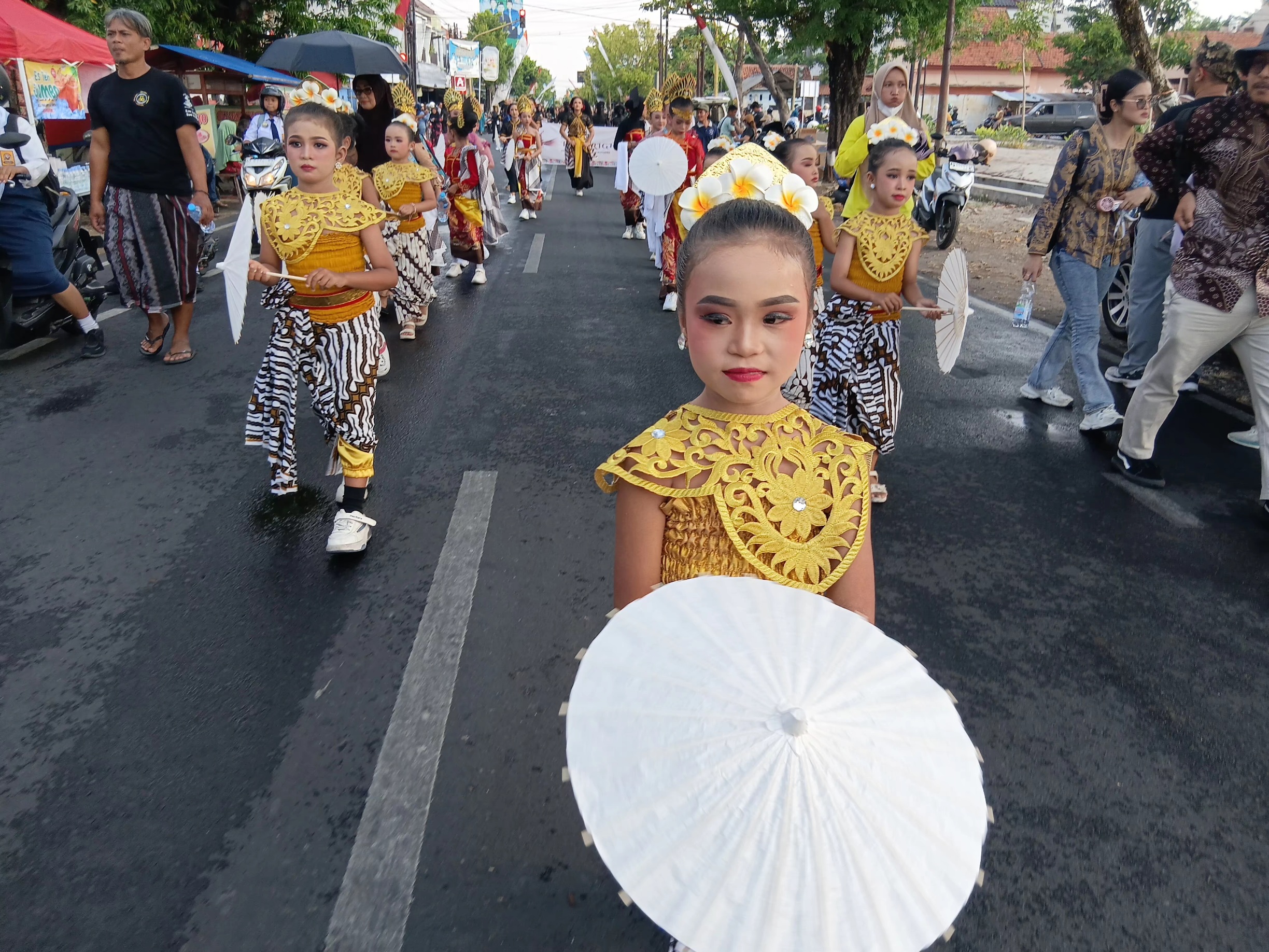 Sorang anak membawa payung dan berdandan ikut karnaval Sragen Batik Heritage Fest 2026, Sabtu (3/10/2026)